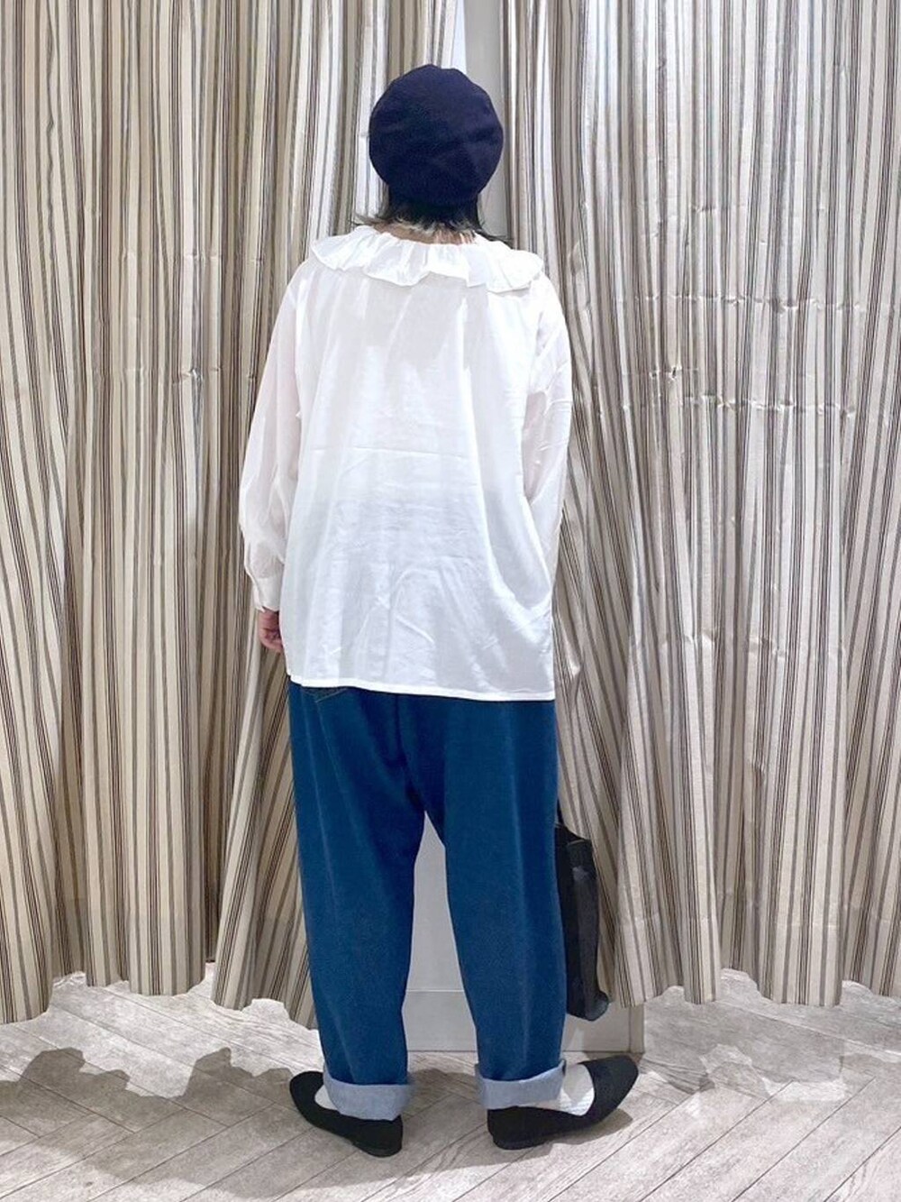 ホワイト系のシャツ/ブラウス、ベージュ系のタンクトップ、ブルー系のデニムパンツを着用したレディースの春コーディネートの3枚目の写真