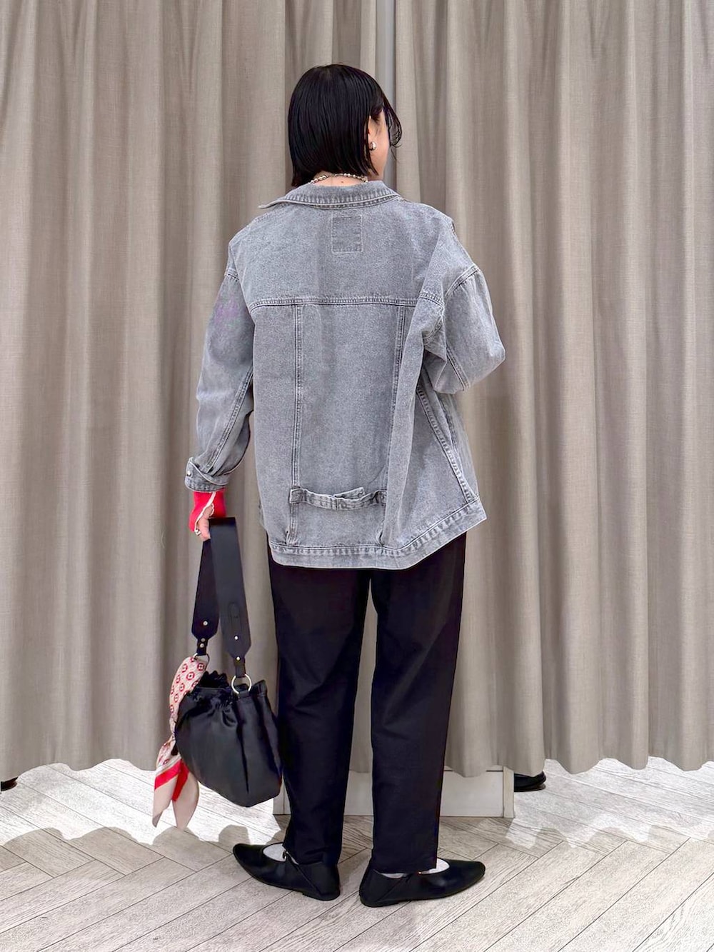 グレー系のデニムジャケット、ブラック系のトートバッグ、ブラック系のその他パンツを着用したレディースの春コーディネートの4枚目の写真