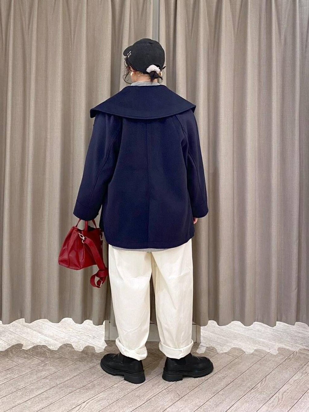 ホワイト系のその他パンツ、ブラウン系のベスト、ブラック系のブーツを着用したレディースの冬コーディネートの4枚目の写真