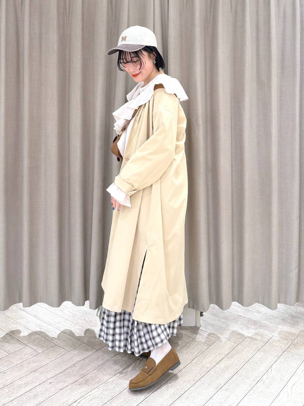 イエロー系のショルダーバッグ、ベージュ系のチェスターコート、イエロー系のローファーを着用したレディースの冬コーディネートの4枚目の写真