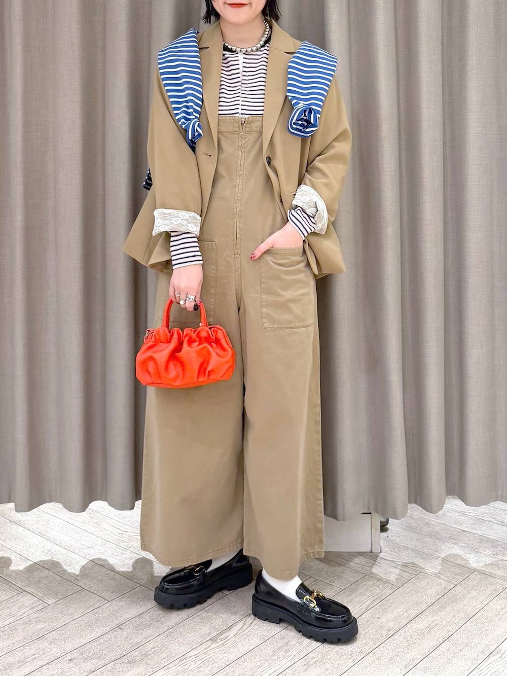 ブラック系のローファー、ベージュ系のサロペット/オーバーオール、オレンジ系のショルダーバッグを着用したレディースの冬コーディネートの7枚目の写真