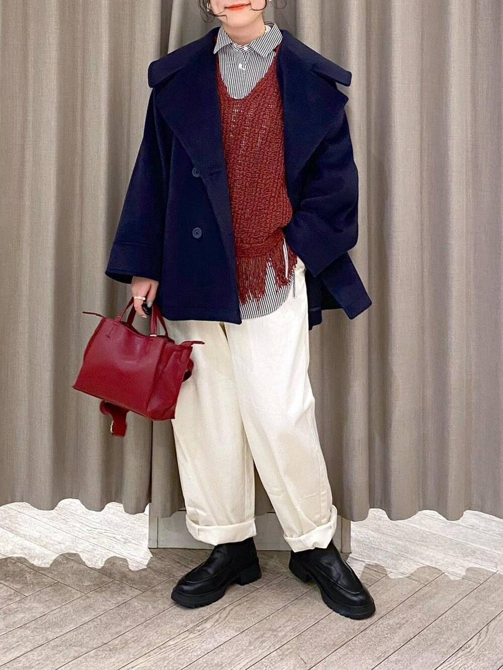 ホワイト系のその他パンツ、ブラウン系のベスト、ブラック系のブーツを着用したレディースの冬コーディネートの6枚目の写真