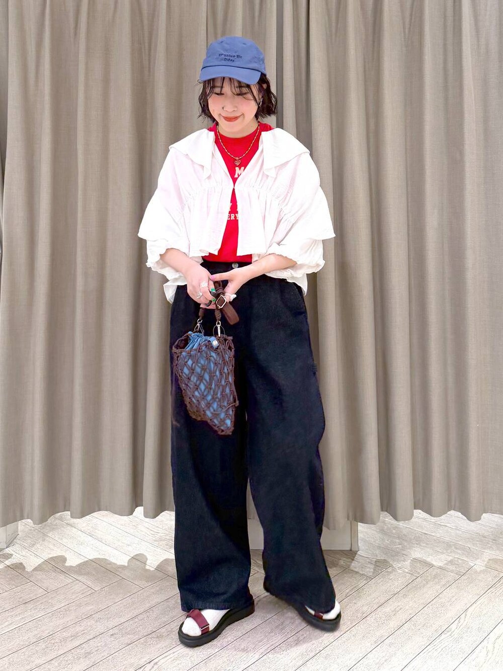 ブラウン系のショルダーバッグ、ブルー系のその他パンツ、レッド系のサンダルを着用したレディースの春コーディネートの3枚目の写真
