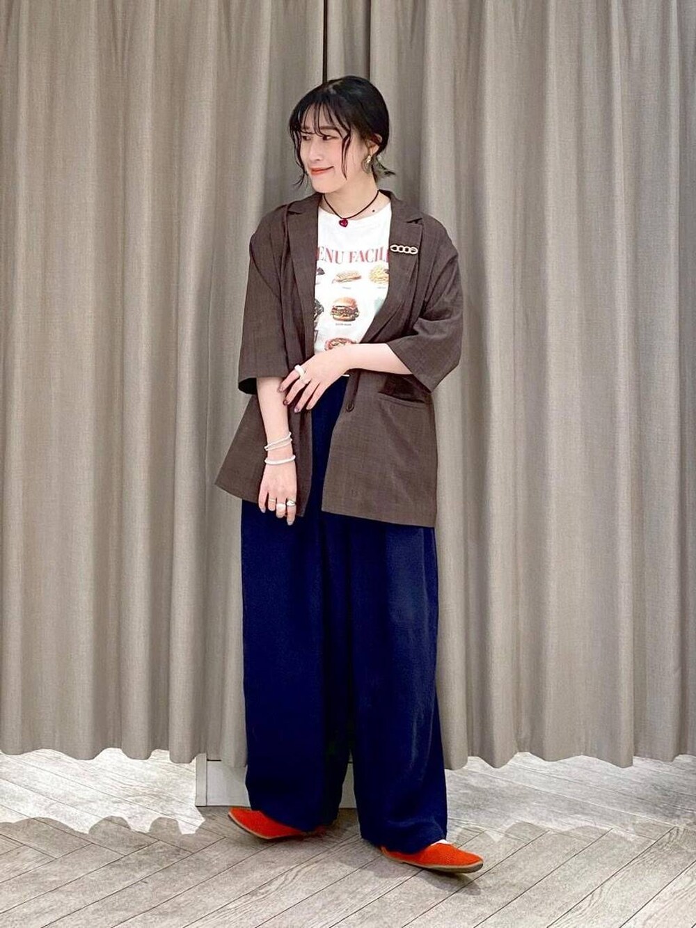 ブラウン系のテーラードジャケット、オレンジ系のパンプス、グレー系のその他パンツを着用したレディースの夏コーディネートの6枚目の写真