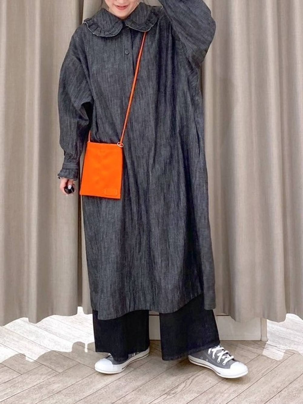ブラック系のデニムパンツ、グレー系のスニーカー、オレンジ系のショルダーバッグを着用したレディースの秋コーディネートの6枚目の写真