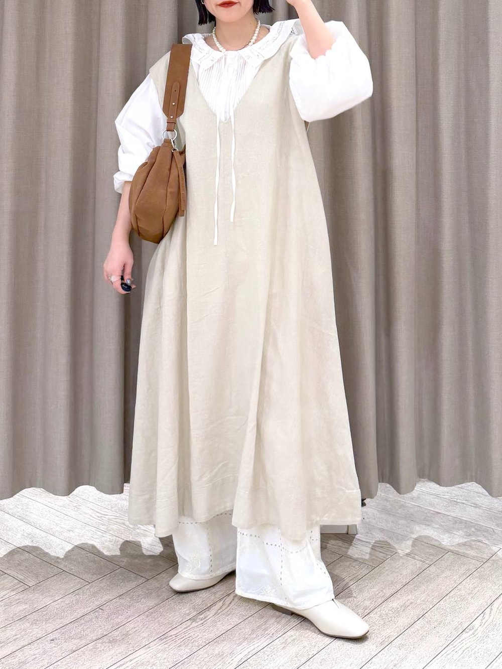 ベージュ系のジャンパースカート、ベージュ系のパンプス、ベージュ系のトートバッグを着用したレディースの冬コーディネートの8枚目の写真