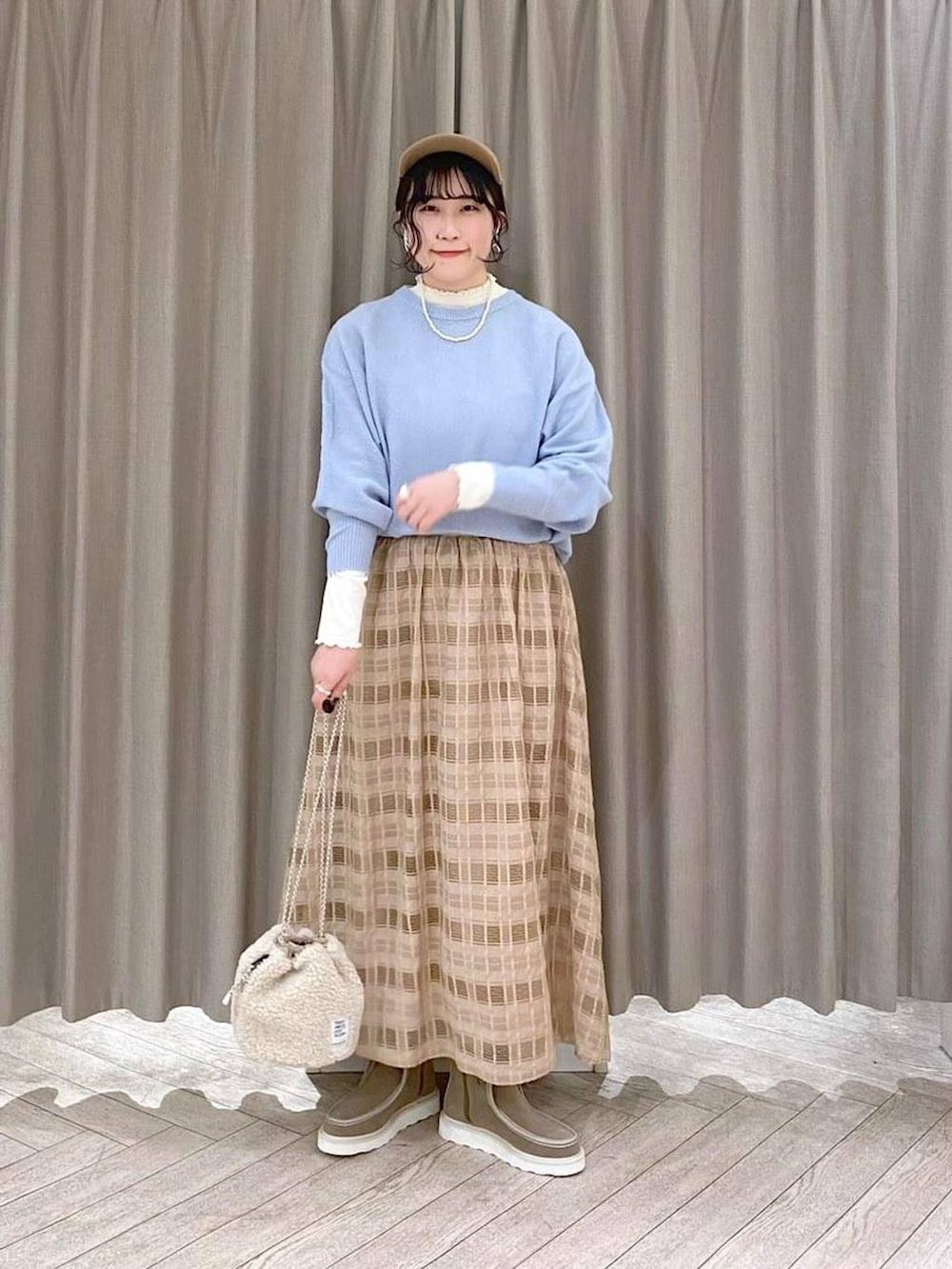 ベージュ系のブルゾン、ホワイト系のTシャツ/カットソー、ベージュ系のハンドバッグを着用したレディースの冬コーディネートの2枚目の写真