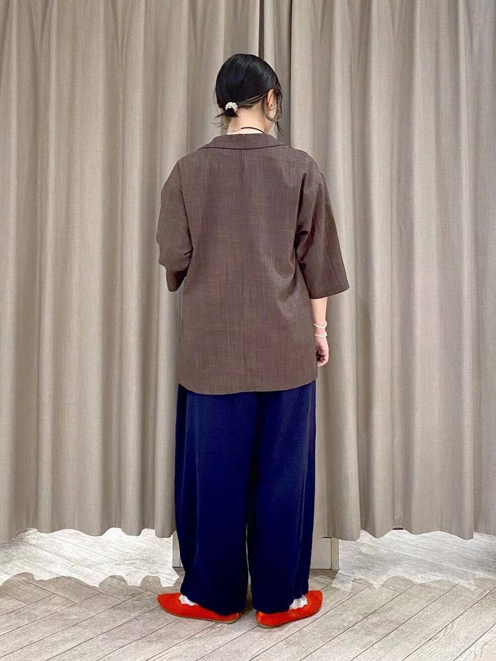 ブラウン系のテーラードジャケット、オレンジ系のパンプス、グレー系のその他パンツを着用したレディースの夏コーディネートの3枚目の写真