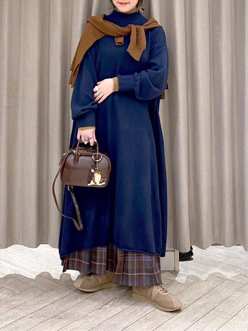 ブラウン系のスカート、イエロー系のカーディガン/ボレロ、ブラウン系のトートバッグを着用したレディースの冬コーディネートの7枚目の写真