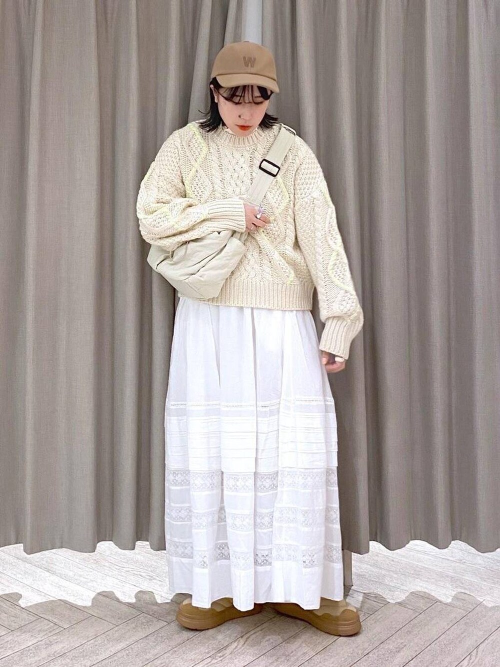 ホワイト系のTシャツ/カットソー、ベージュ系のニット/セーター、ホワイト系のスカートを着用したレディースの秋コーディネートの3枚目の写真