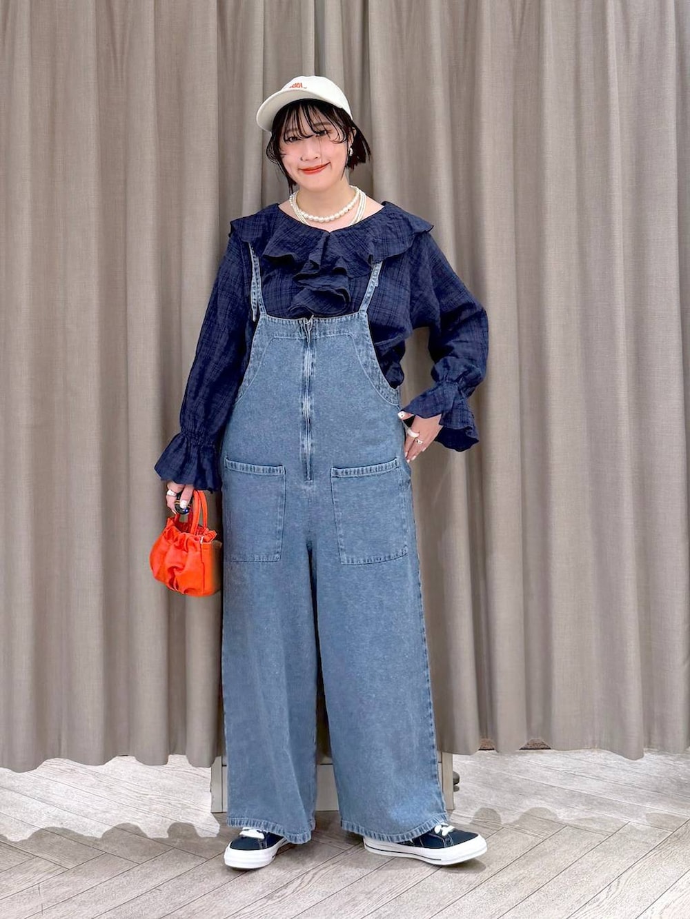 ブルー系のスニーカー、ブルー系のサロペット/オーバーオール、オレンジ系のショルダーバッグを着用したレディースの冬コーディネートの10枚目の写真