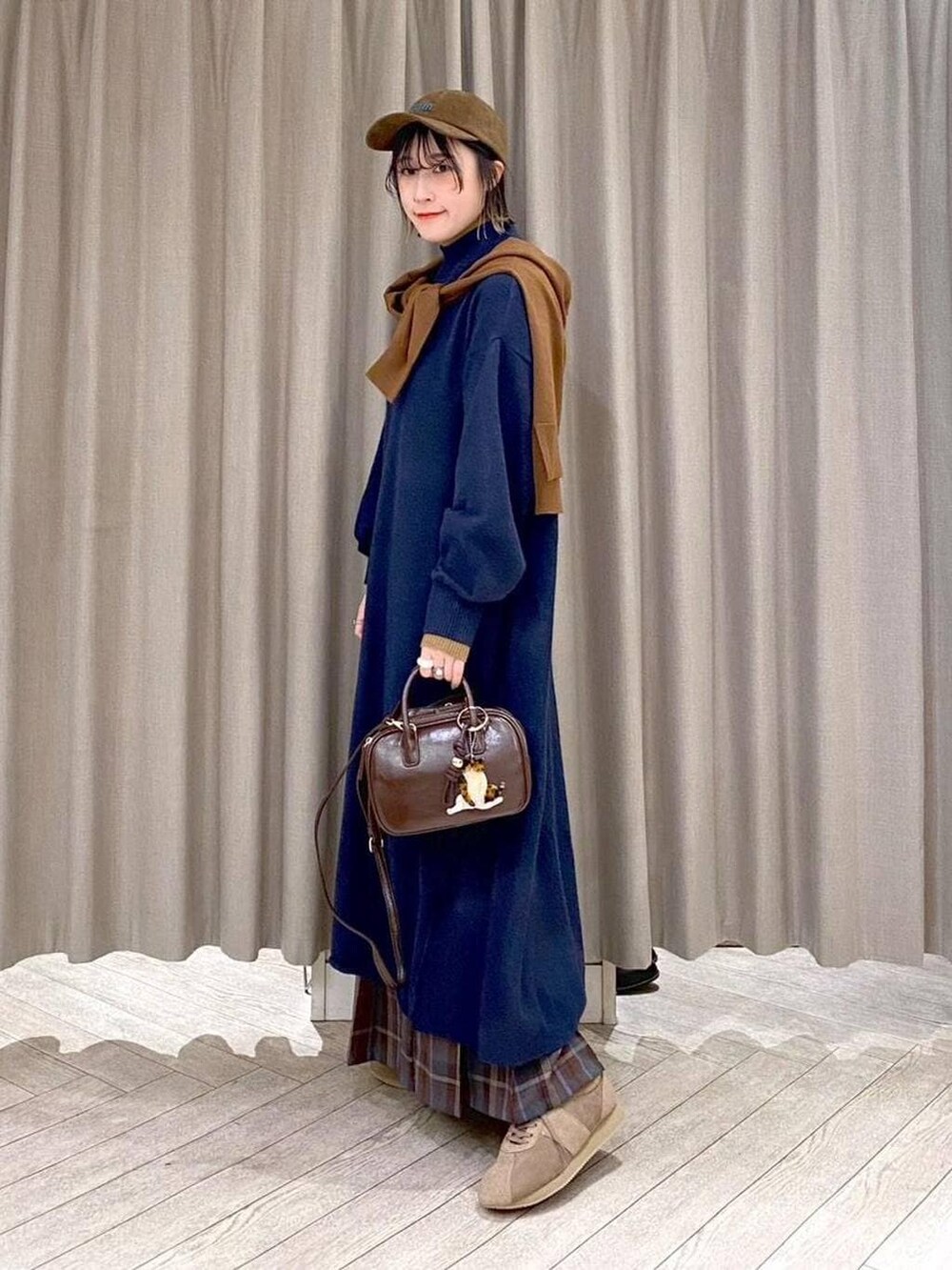 ブラウン系のスカート、イエロー系のカーディガン/ボレロ、ブラウン系のトートバッグを着用したレディースの冬コーディネートの4枚目の写真