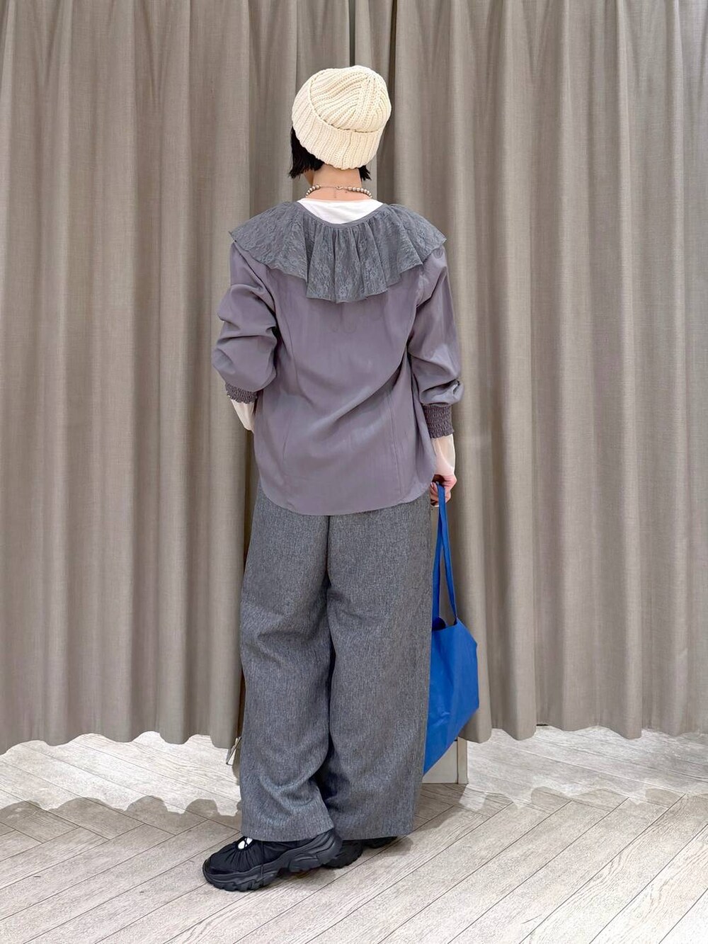 ホワイト系のTシャツ/カットソー、グレー系のスラックス、ブルー系のトートバッグを着用したレディースの冬コーディネートの5枚目の写真