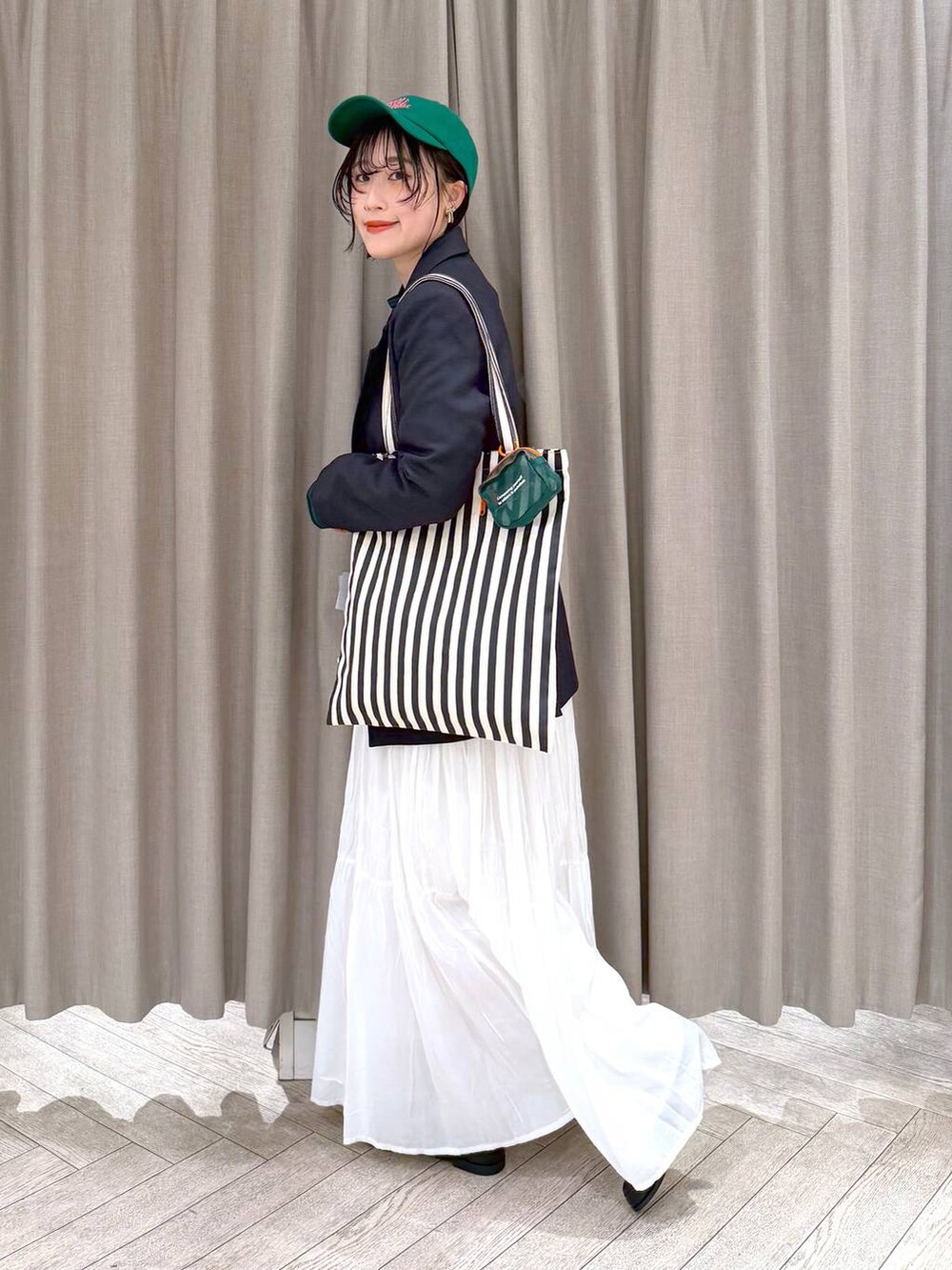 ホワイト系のスカート、ブラック系のローファー、ベージュ系のトートバッグを着用したレディースの冬コーディネートの4枚目の写真