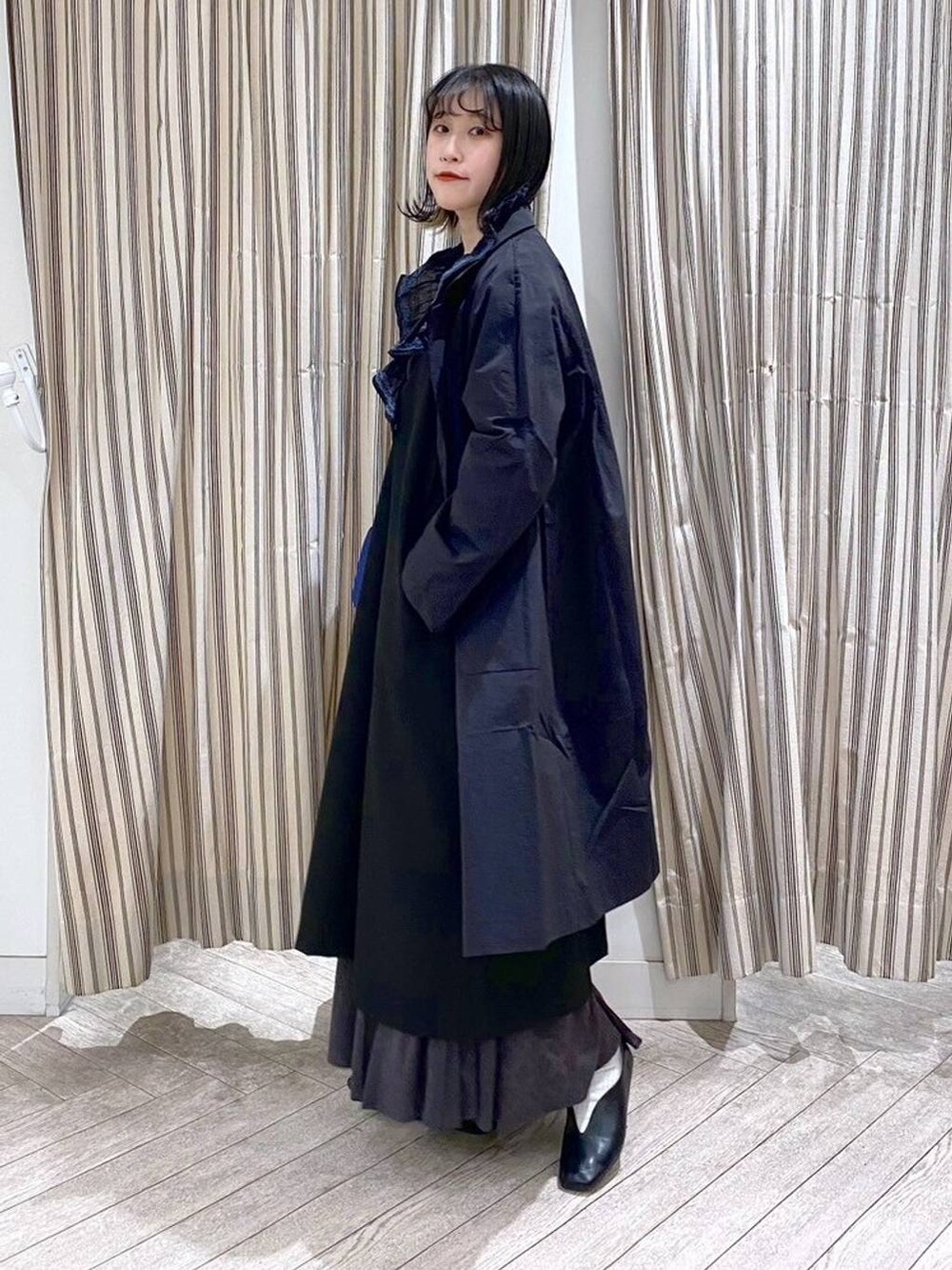 ブラック系のシャツ/ブラウス、ブラック系のジャンパースカート、ブラック系のスカートを着用したレディースの春コーディネートの3枚目の写真