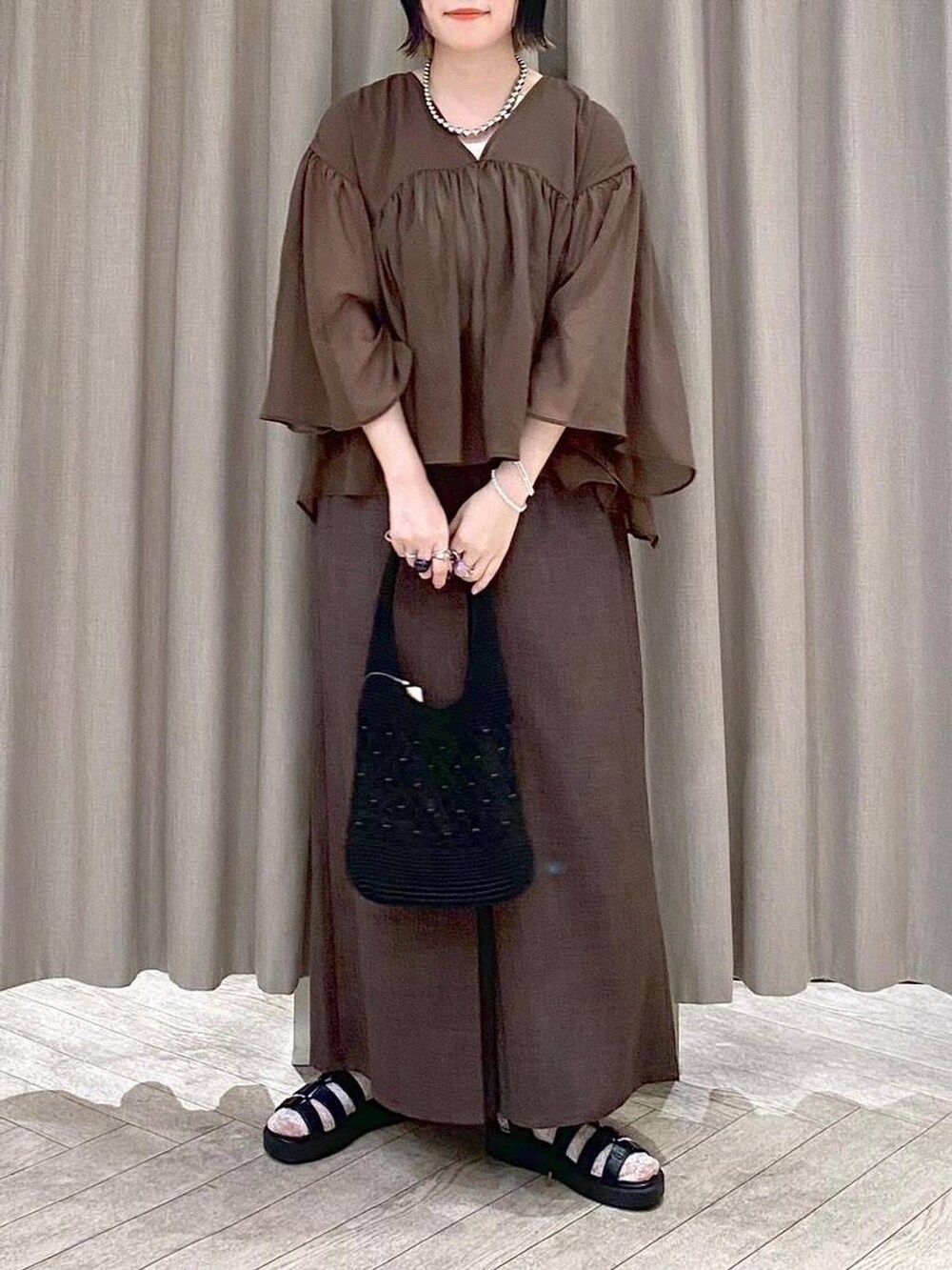 ブラウン系のその他パンツ、ブラウン系のシャツ/ブラウス、ブラック系のトートバッグを着用したレディースの夏コーディネートの7枚目の写真