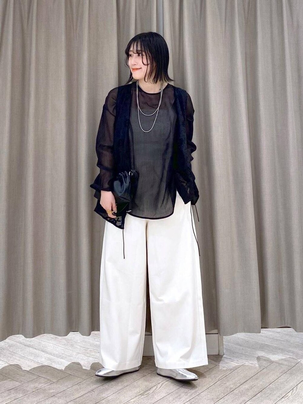 ホワイト系のその他パンツ、ブラック系のショルダーバッグ、その他のパンプスを着用したレディースの秋コーディネートの2枚目の写真