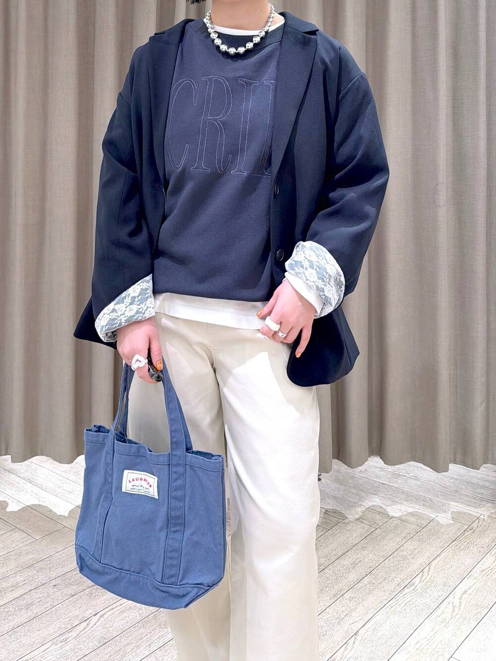 ブルー系のトートバッグ、ブルー系のスニーカー、ベージュ系のその他パンツを着用したレディースの春コーディネートの6枚目の写真