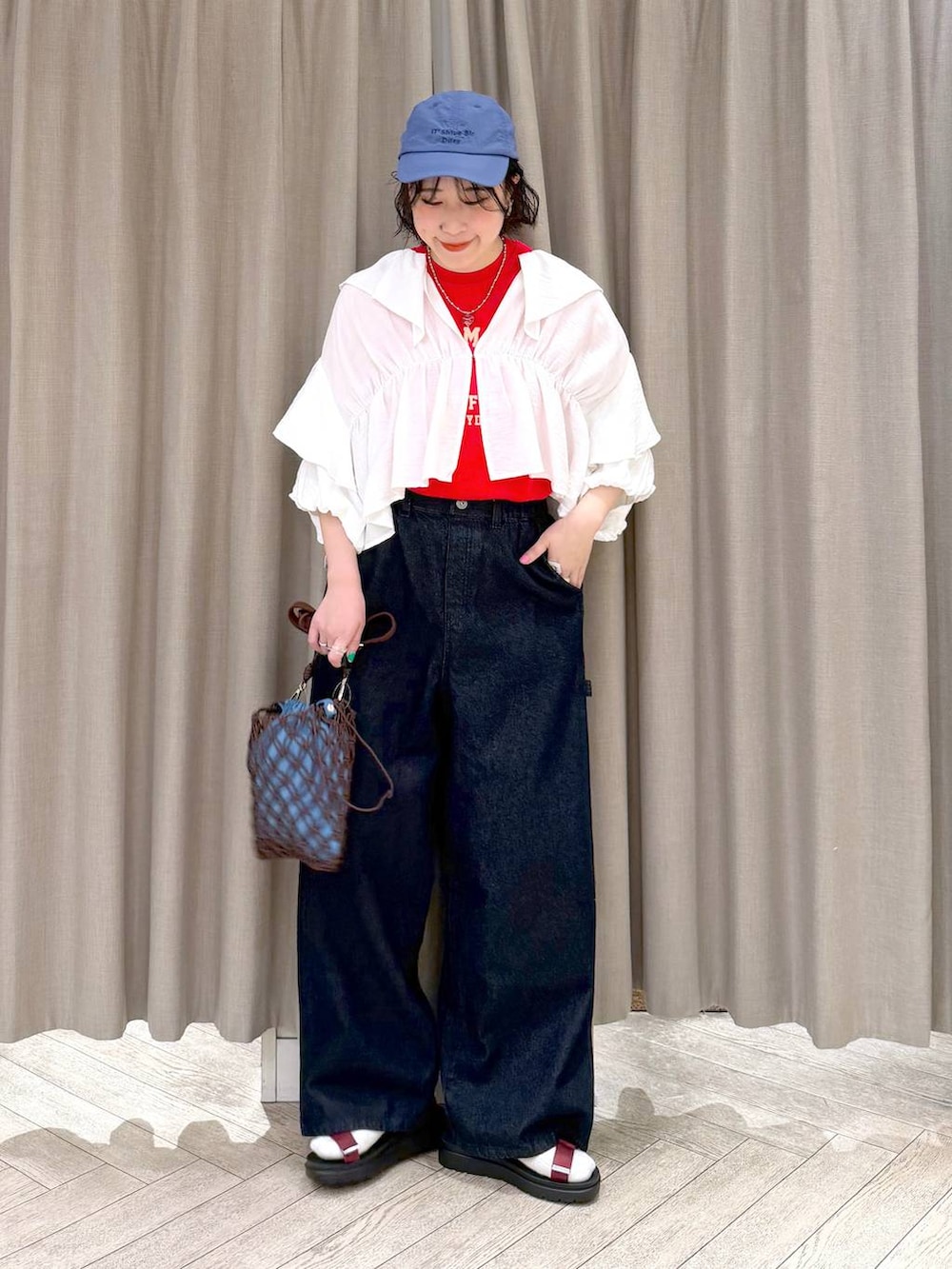 ブラウン系のショルダーバッグ、ブルー系のその他パンツ、レッド系のサンダルを着用したレディースの春コーディネートの2枚目の写真