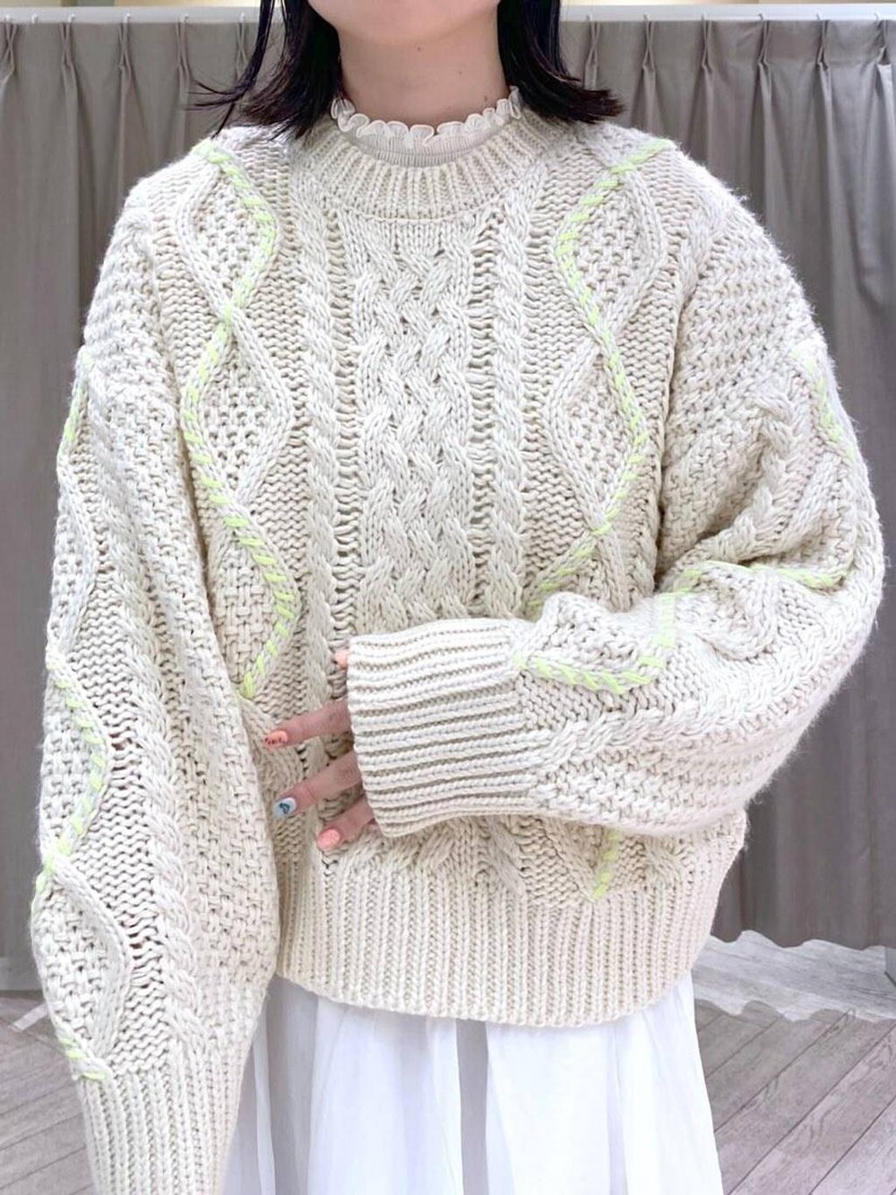 ホワイト系のTシャツ/カットソー、ベージュ系のニット/セーター、ホワイト系のスカートを着用したレディースの秋コーディネートの5枚目の写真