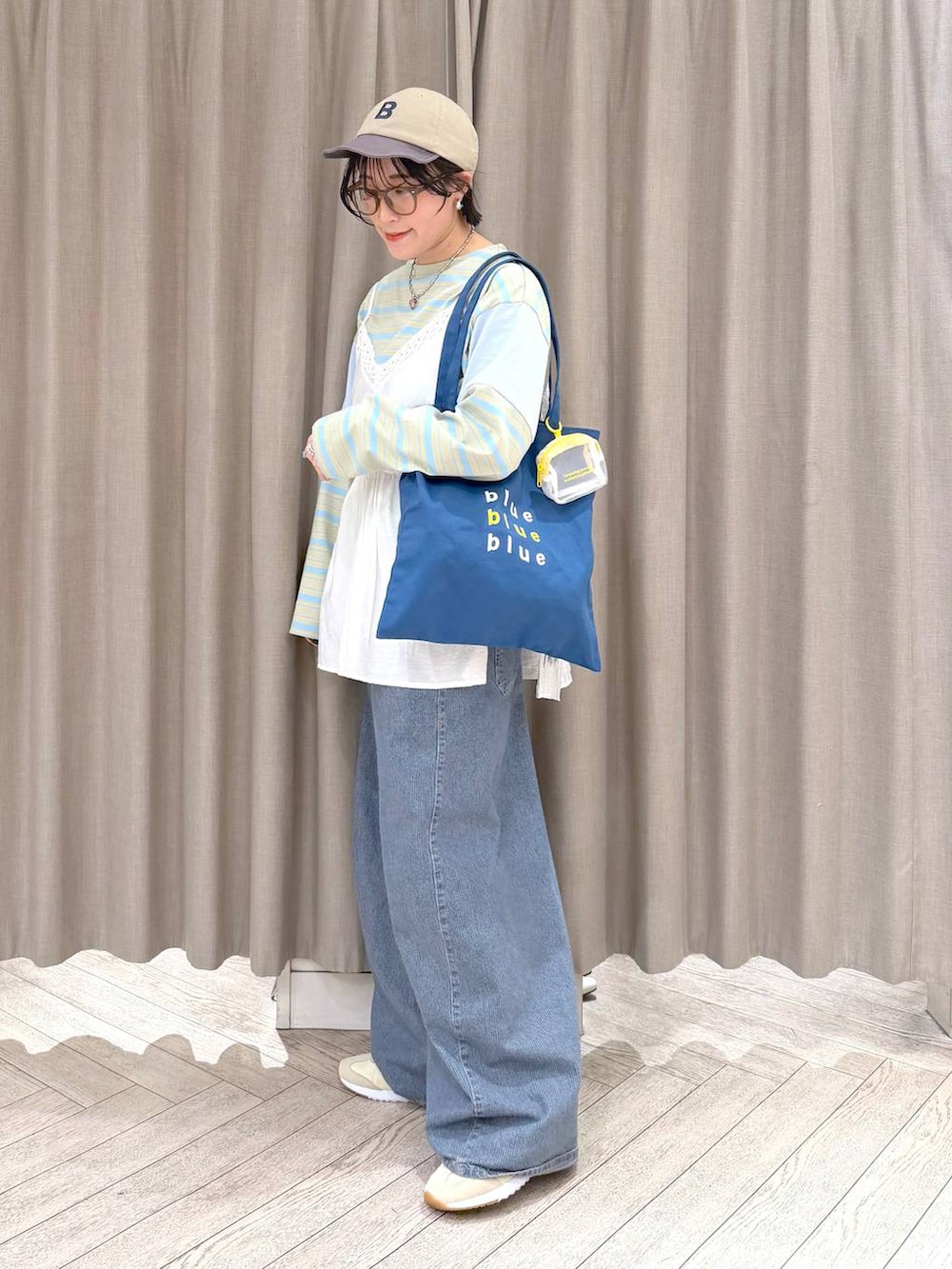 ブルー系のデニムパンツ、ブルー系のトートバッグ、ブルー系のTシャツ/カットソーを着用したレディースの春コーディネートの4枚目の写真