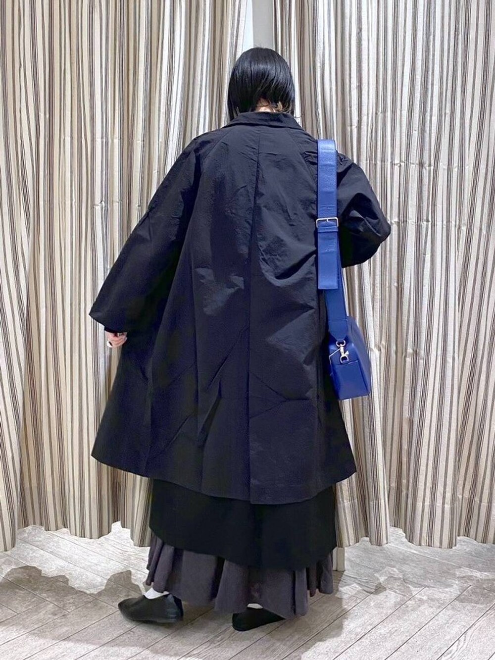 ブラック系のシャツ/ブラウス、ブラック系のジャンパースカート、ブラック系のスカートを着用したレディースの春コーディネートの10枚目の写真