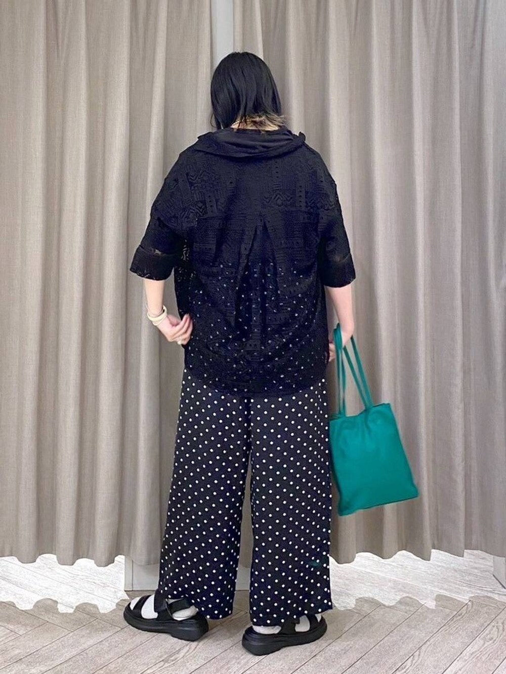 ブラック系のTシャツ/カットソー、ブラック系のサンダル、グリーン系のショルダーバッグを着用したレディースの春コーディネートの4枚目の写真