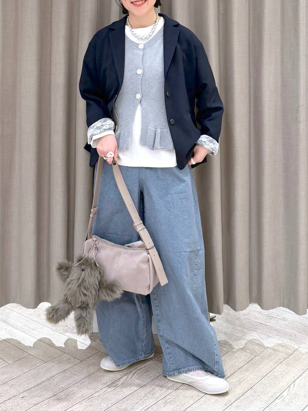 ブルー系のデニムパンツ、ブルー系のテーラードジャケット、グレー系のショルダーバッグを着用したレディースの春コーディネートの9枚目の写真