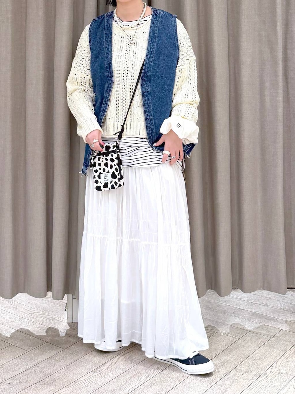 ブルー系のスニーカー、ブルー系のベスト、その他のショルダーバッグを着用したレディースの冬コーディネートの6枚目の写真