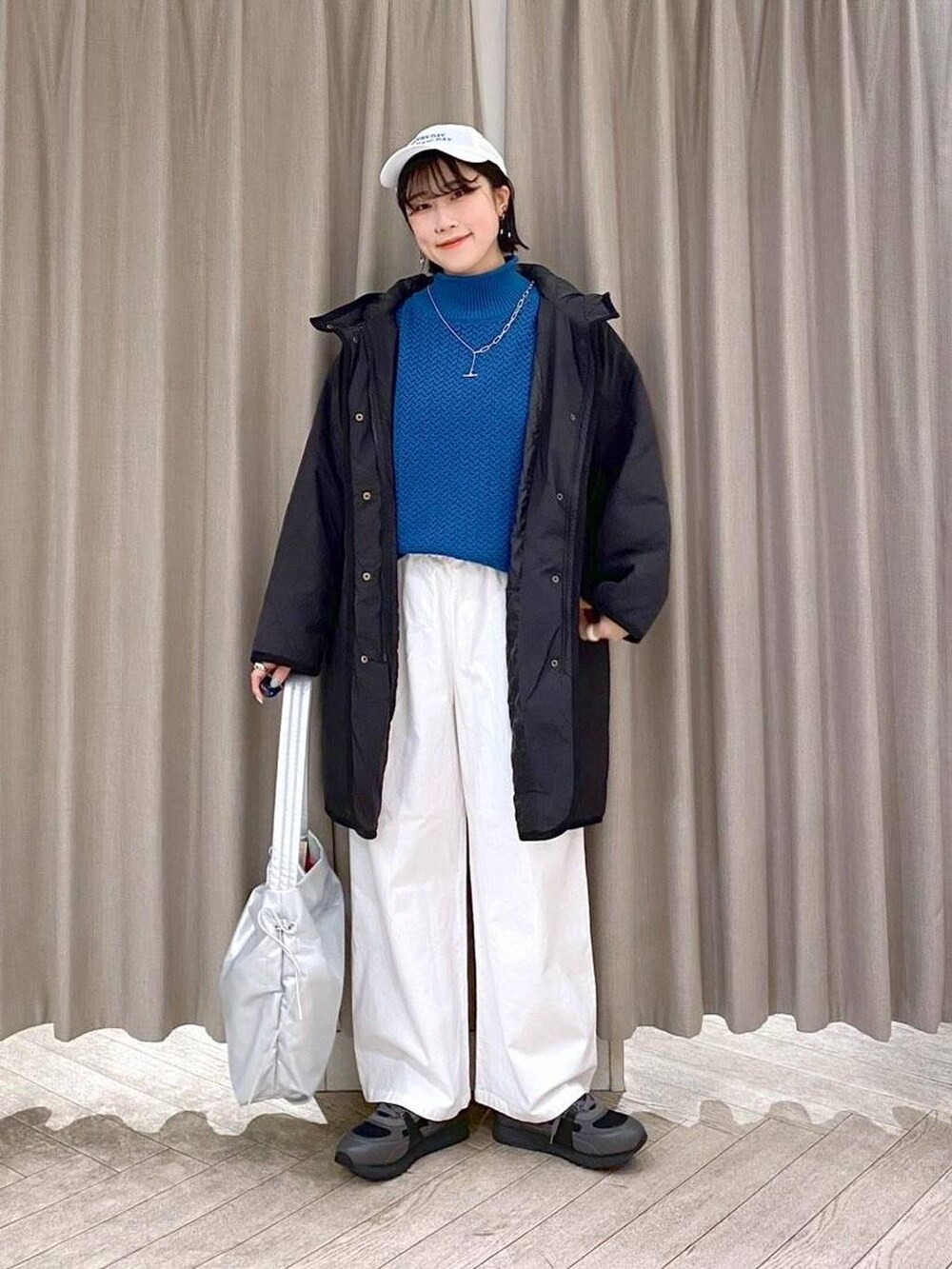 ブラック系のスニーカー、ブラック系のダウンジャケット/コート、その他のショルダーバッグを着用したレディースの冬コーディネートの2枚目の写真