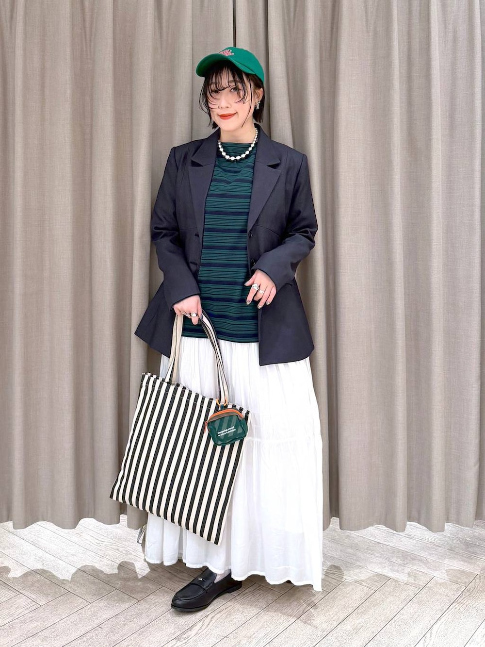 ホワイト系のスカート、ブラック系のローファー、ベージュ系のトートバッグを着用したレディースの冬コーディネートの10枚目の写真