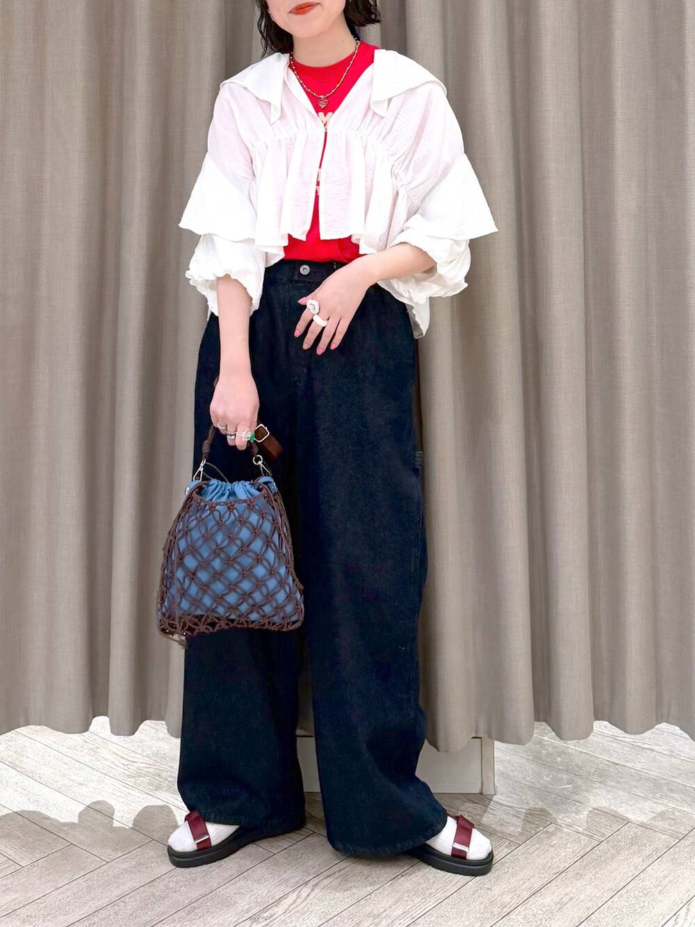 ブラウン系のショルダーバッグ、ブルー系のその他パンツ、レッド系のサンダルを着用したレディースの春コーディネートの6枚目の写真