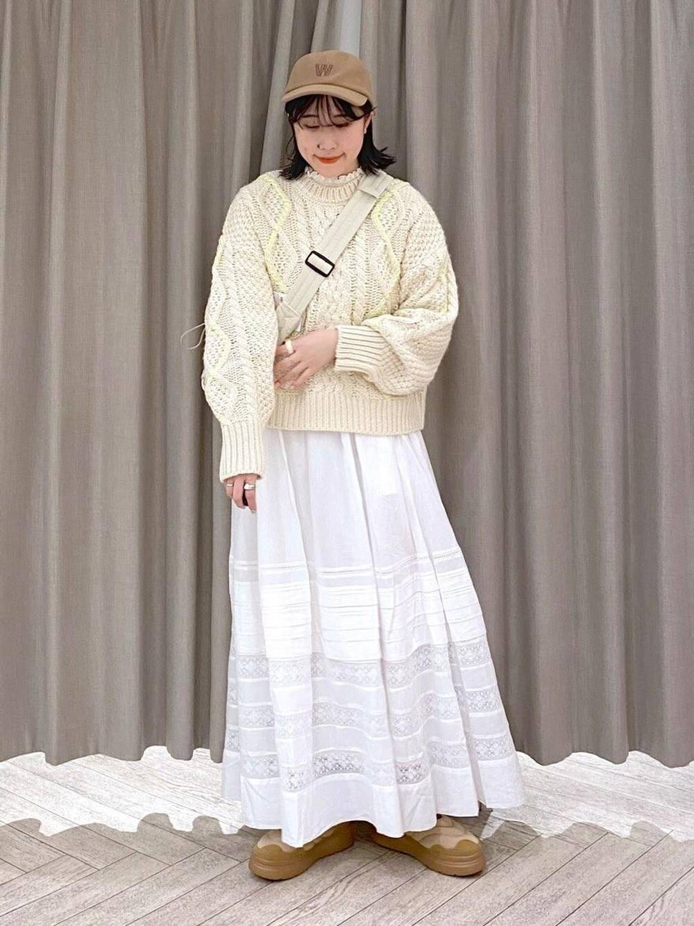 ホワイト系のTシャツ/カットソー、ベージュ系のニット/セーター、ホワイト系のスカートを着用したレディースの秋コーディネートの9枚目の写真