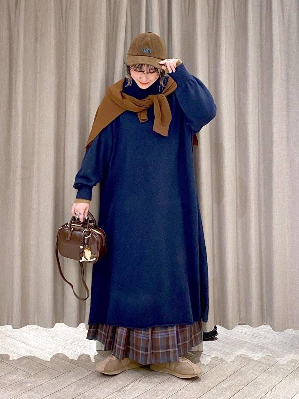 ブラウン系のスカート、イエロー系のカーディガン/ボレロ、ブラウン系のトートバッグを着用したレディースの冬コーディネートの9枚目の写真