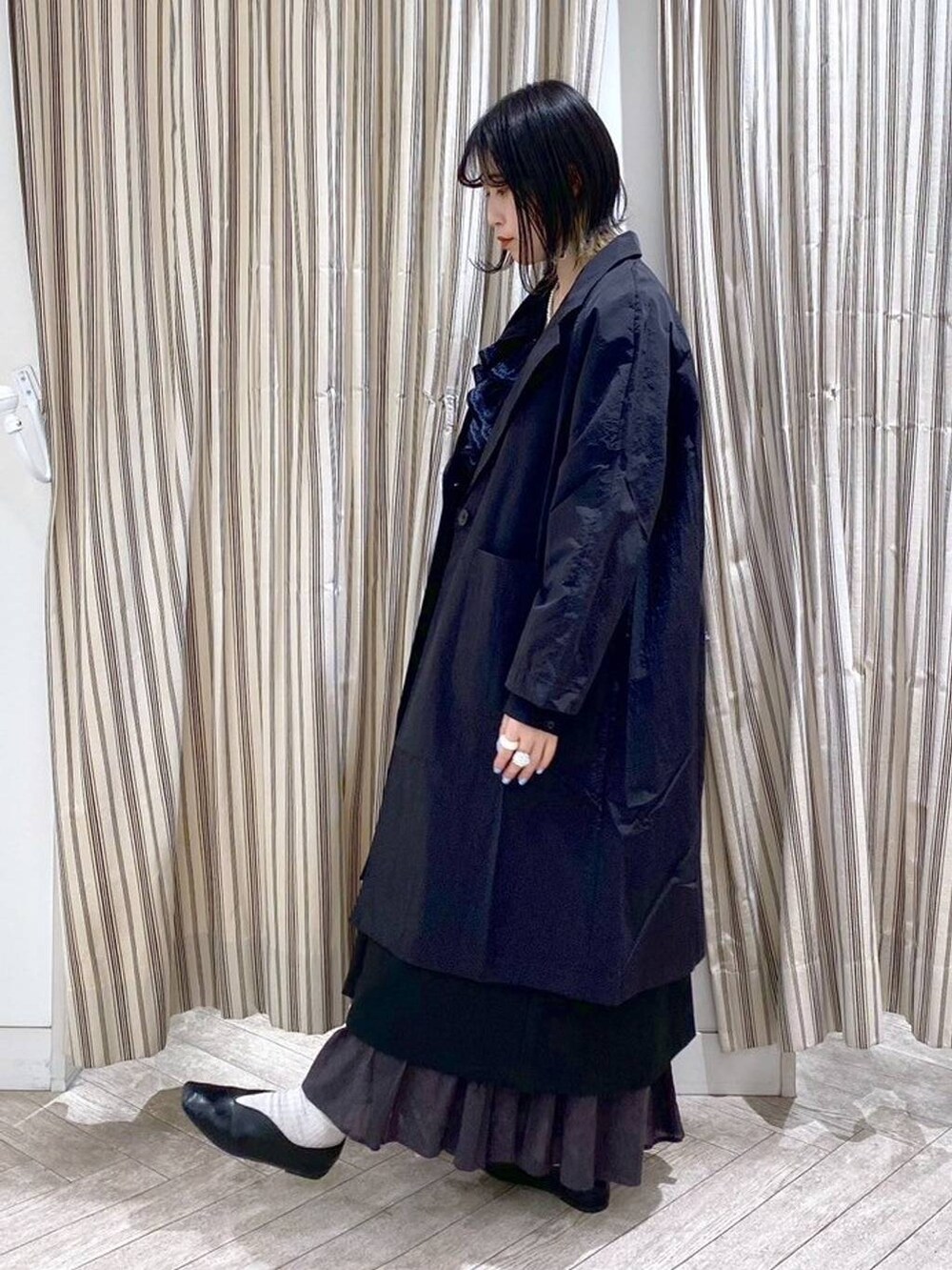 ブラック系のシャツ/ブラウス、ブラック系のジャンパースカート、ブラック系のスカートを着用したレディースの春コーディネートの9枚目の写真