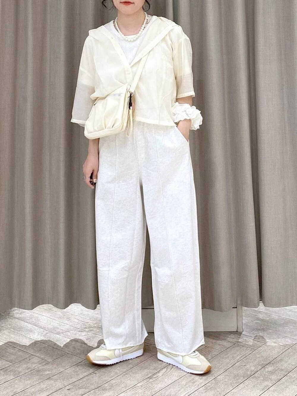 ベージュ系のショルダーバッグ、ベージュ系のシャツ/ブラウス、ベージュ系のスウェットパンツを着用したレディースの夏コーディネートの6枚目の写真