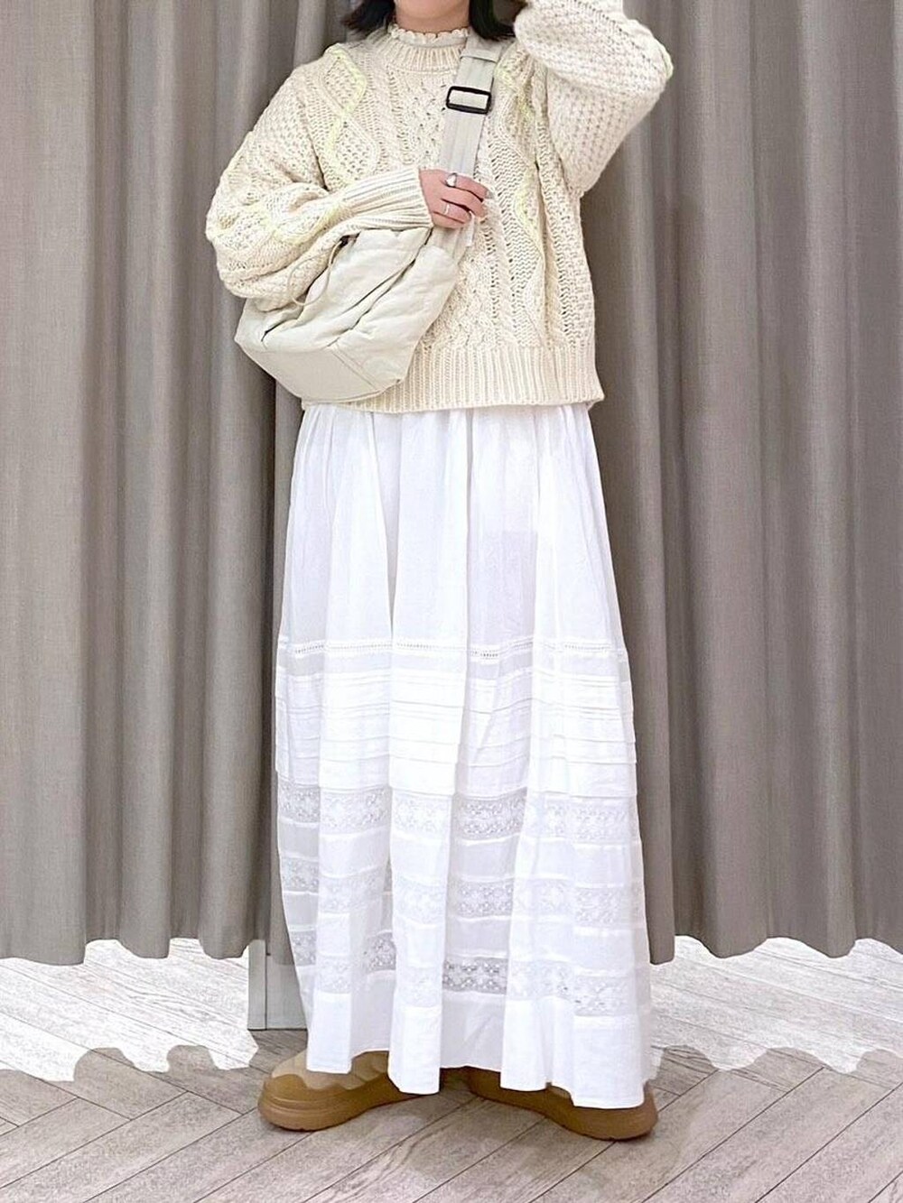 ホワイト系のTシャツ/カットソー、ベージュ系のニット/セーター、ホワイト系のスカートを着用したレディースの秋コーディネートの6枚目の写真