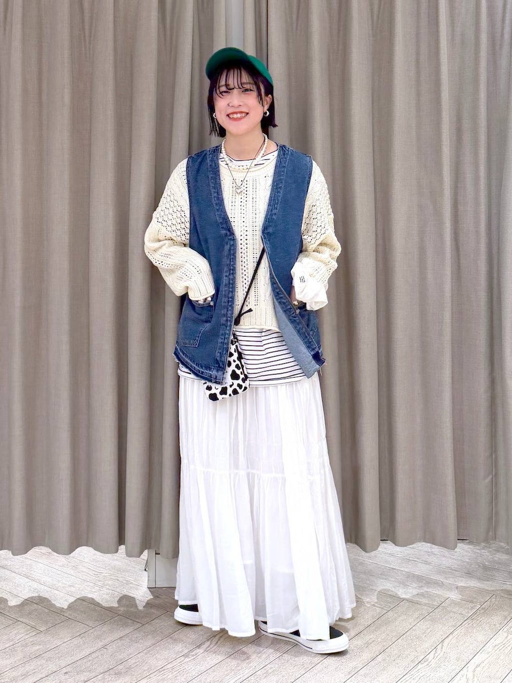 ブルー系のスニーカー、ブルー系のベスト、その他のショルダーバッグを着用したレディースの冬コーディネートの2枚目の写真