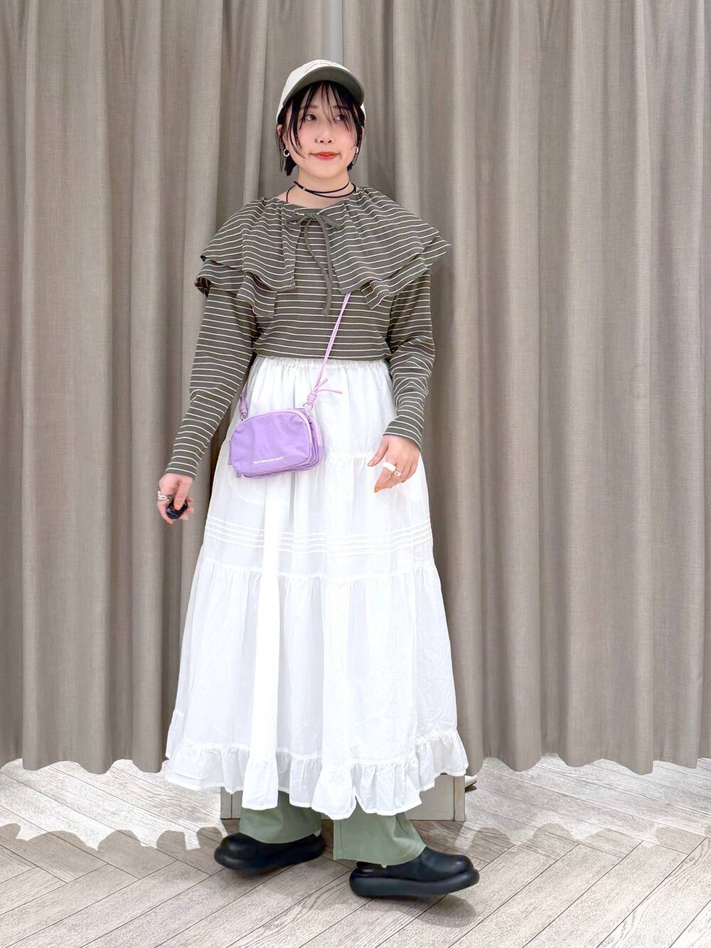 ブラック系のサンダル、グリーン系のその他パンツ、パープル系のショルダーバッグを着用したレディースの春コーディネートの3枚目の写真