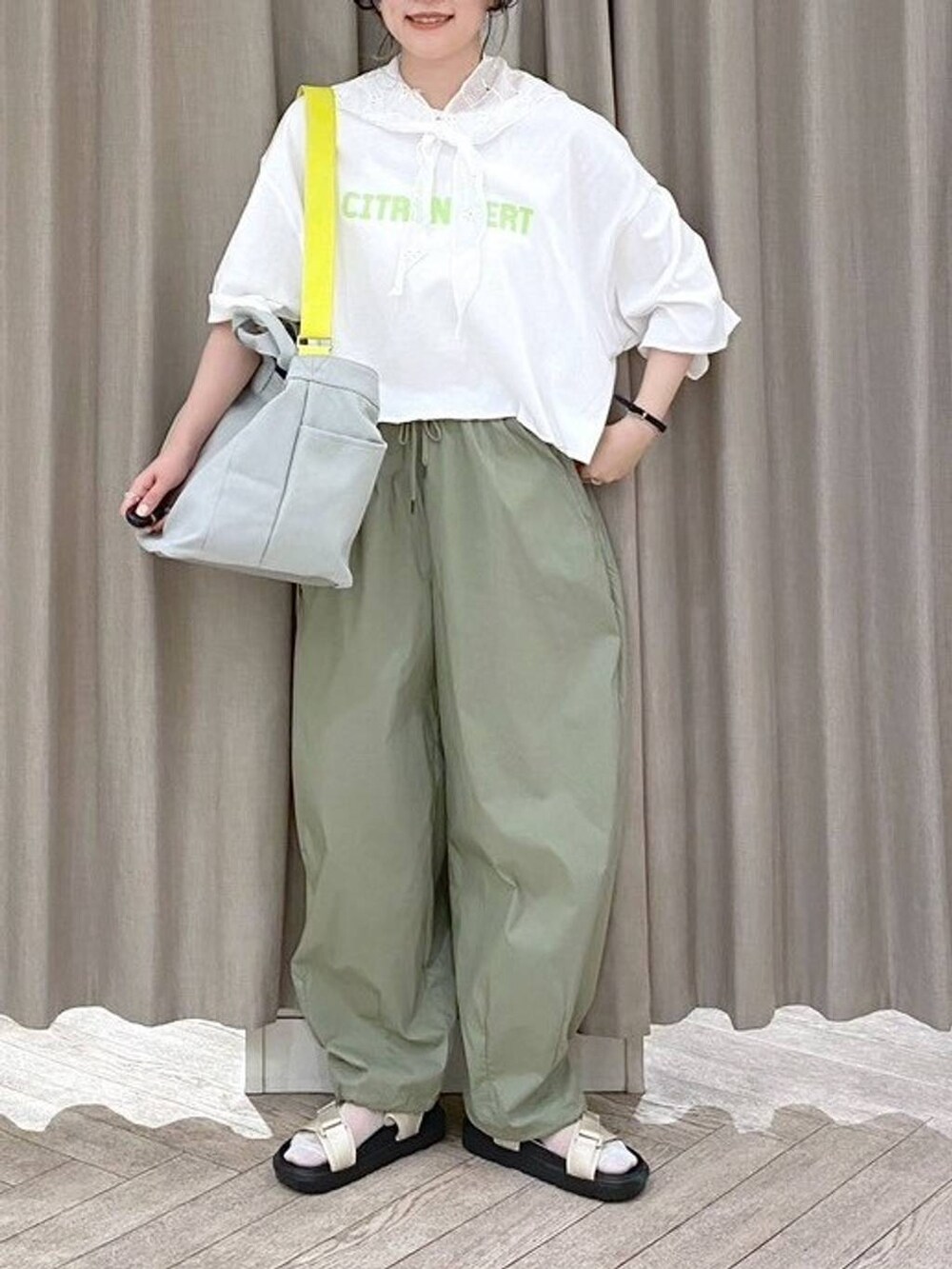 ベージュ系のサンダル、グリーン系のTシャツ/カットソー、グレー系のトートバッグを着用したレディースの夏コーディネートの5枚目の写真