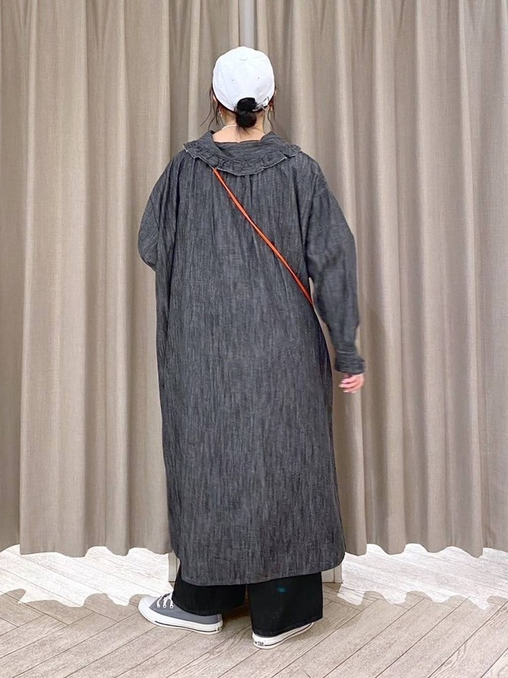 ブラック系のデニムパンツ、グレー系のスニーカー、オレンジ系のショルダーバッグを着用したレディースの秋コーディネートの5枚目の写真