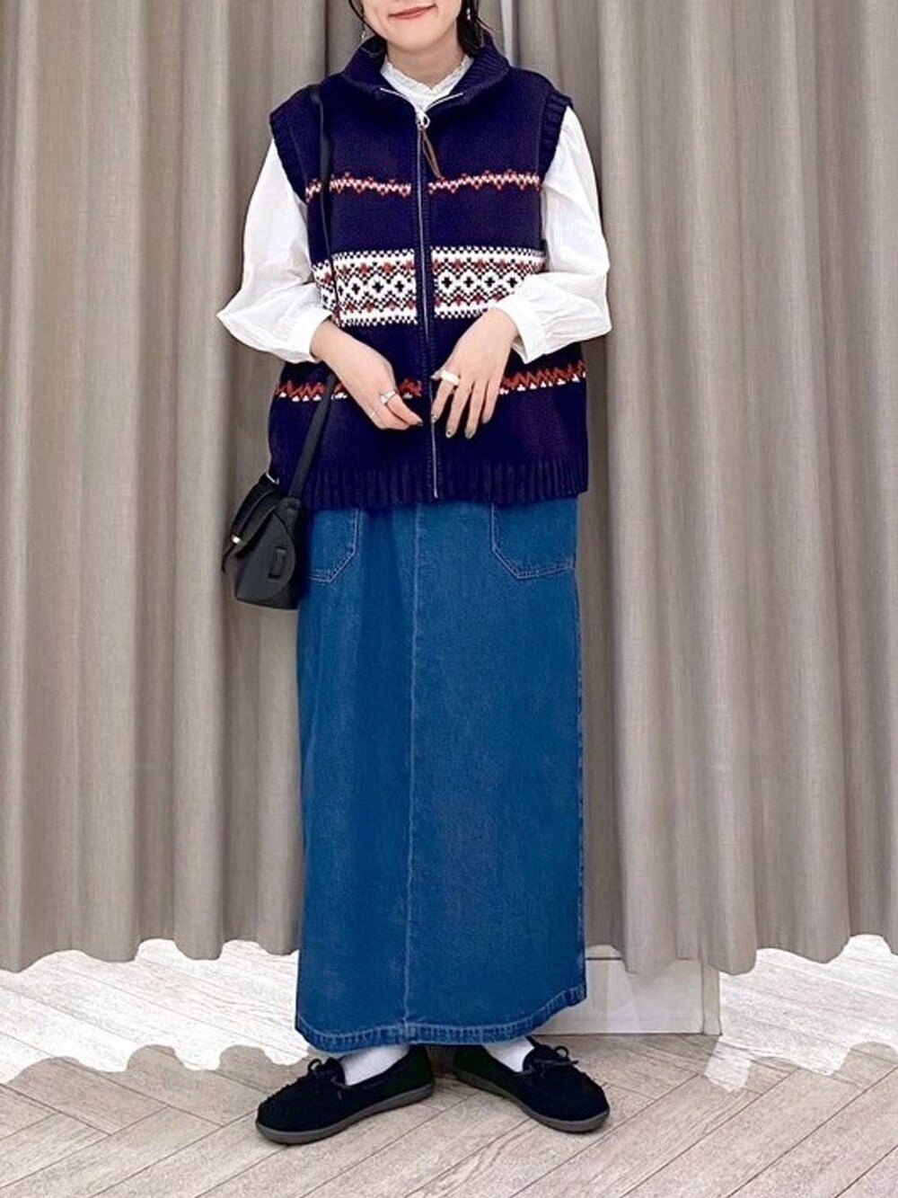 ブラック系のショルダーバッグ、ブルー系のワンピース、ブラック系のヘアバンドを着用したレディースの秋コーディネートの7枚目の写真