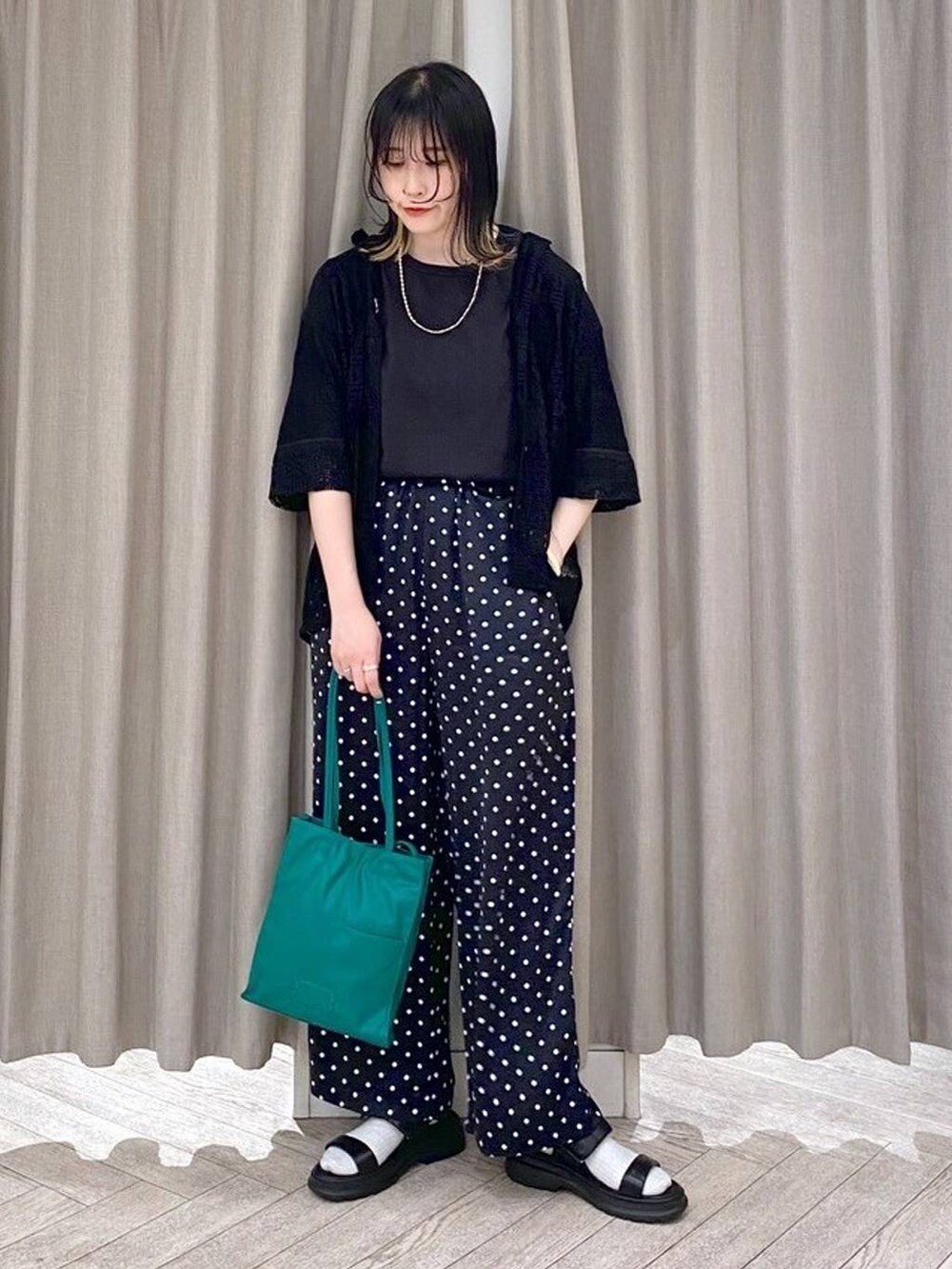 ブラック系のTシャツ/カットソー、ブラック系のサンダル、グリーン系のショルダーバッグを着用したレディースの春コーディネートの8枚目の写真