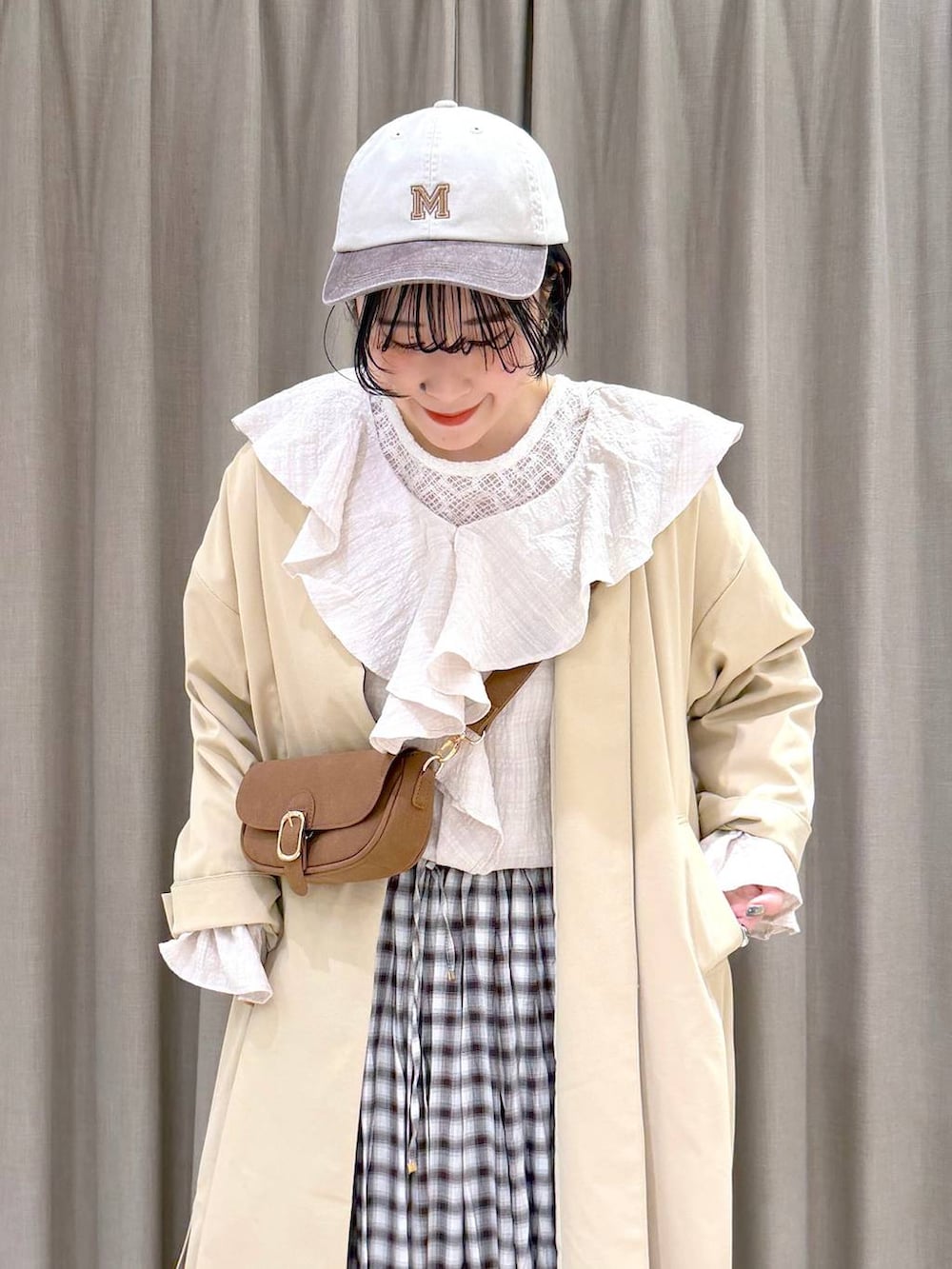 イエロー系のショルダーバッグ、ベージュ系のチェスターコート、イエロー系のローファーを着用したレディースの冬コーディネートの6枚目の写真