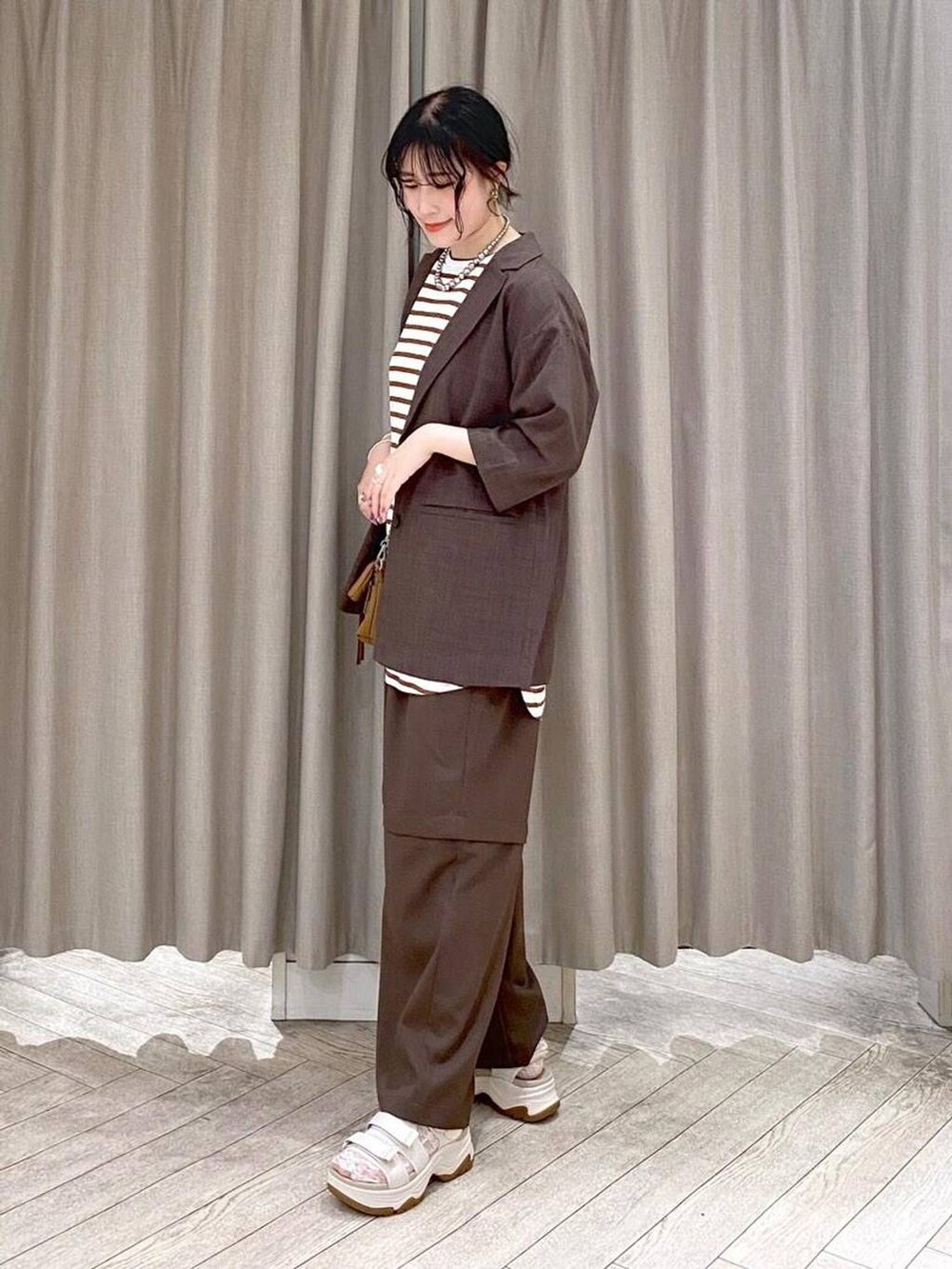 ブラウン系のテーラードジャケット、ブラウン系のその他パンツ、その他のTシャツ/カットソーを着用したレディースの夏コーディネートの2枚目の写真