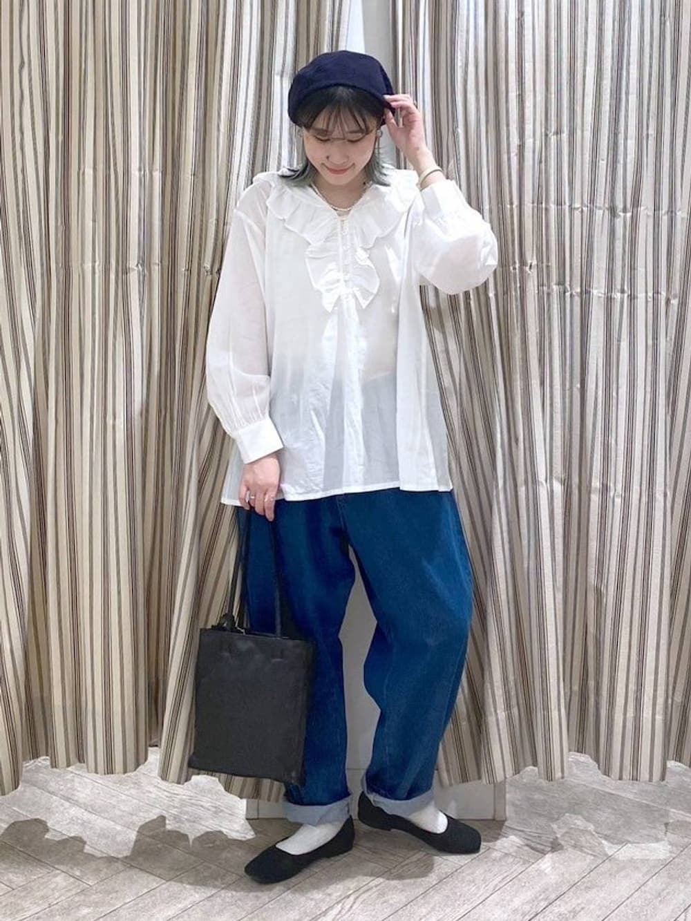 ホワイト系のシャツ/ブラウス、ベージュ系のタンクトップ、ブルー系のデニムパンツを着用したレディースの春コーディネートの9枚目の写真