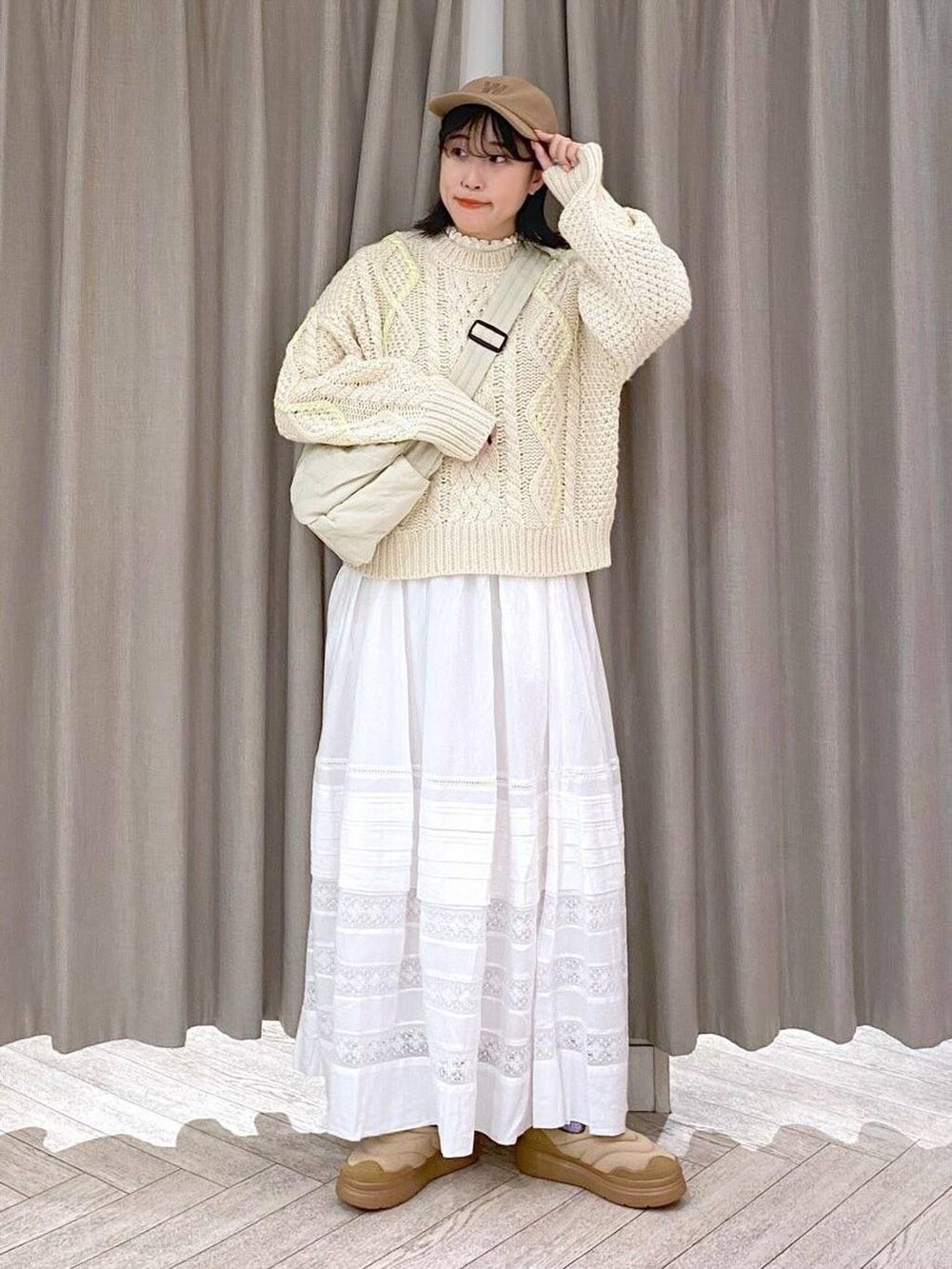 ホワイト系のTシャツ/カットソー、ベージュ系のニット/セーター、ホワイト系のスカートを着用したレディースの秋コーディネートの2枚目の写真