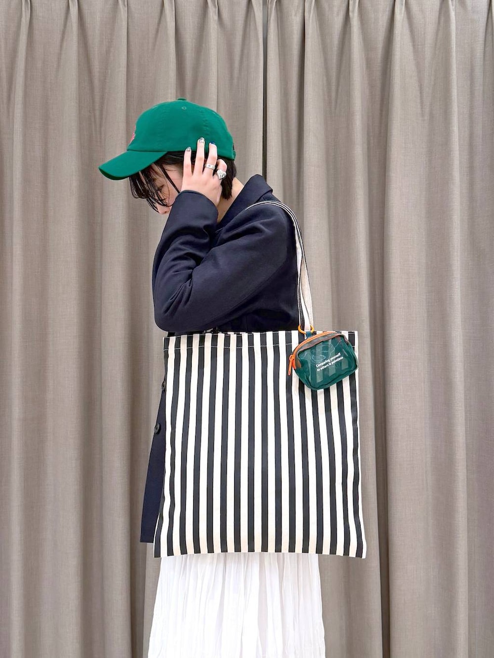 ホワイト系のスカート、ブラック系のローファー、ベージュ系のトートバッグを着用したレディースの冬コーディネートの6枚目の写真