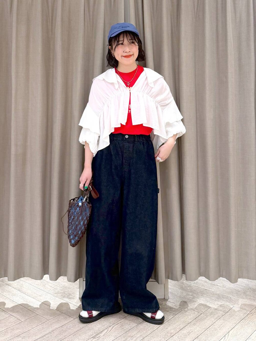 ブラウン系のショルダーバッグ、ブルー系のその他パンツ、レッド系のサンダルを着用したレディースの春コーディネートの9枚目の写真