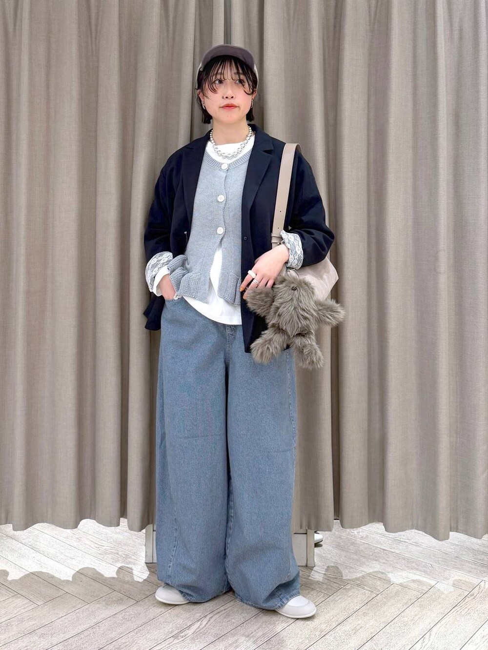 ブルー系のデニムパンツ、ブルー系のテーラードジャケット、グレー系のショルダーバッグを着用したレディースの春コーディネートの2枚目の写真